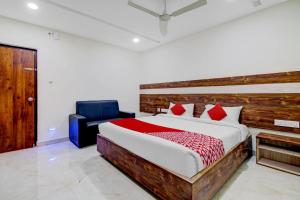 1 dormitorio con 1 cama grande y 1 silla azul en Collection O Hotel Vihari Grand, en Vijayawāda
