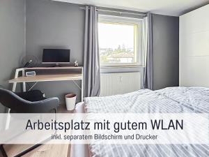 バート・ザクサにあるHaFe Ferienwohnung Bad Sachsa - waldnah, hundefreundlich, Smart Home Ausstattungのベッドルーム1室(ベッド1台、デスク、コンピュータ付)