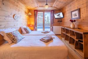 a bedroom with two beds in a log cabin at Chalet Dauphin - Chalets pour 15 Personnes 264 in LʼHuez
