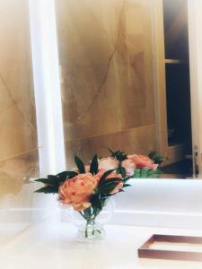 un jarrón de flores en un mostrador frente a un espejo en C & A Suites - Athos Suite, en Káthikas