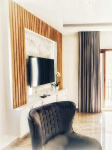 a living room with a black leather chair and a television at C & A Suites - Athos Suite in Kathikas