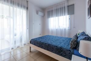 een slaapkamer met een bed met een blauw dekbed bij Beautiful 2 bed apartment in Paphos Cyprus in Paphos City