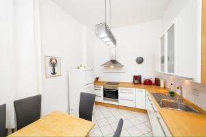 柏林的住宿－Great Central City Apartments Mitte Museumsinsel，厨房配有桌子和白色冰箱。