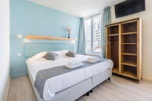 Schlafzimmer mit einem Bett mit weißer Bettwäsche und einem Fenster in der Unterkunft Hotel José in Blankenberge