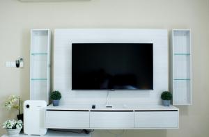 een woonkamer met een grote televisie aan de muur bij Puteri Harbour - Wonderful Studio by Cowidea in Nusajaya +43 foto's