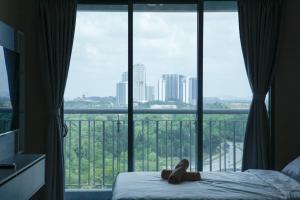 een teddybeer op een bed voor een raam bij Puteri Harbour - Wonderful Studio by Cowidea in Nusajaya