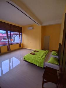 Un dormitorio con una cama con sábanas verdes. en Mooipark Hotel Sorong en Sorong