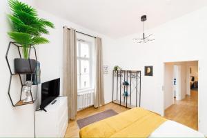 a white living room with a tv and a plant at Great Central City Apartments Mitte Museumsinsel in Berlin