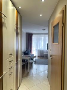 a kitchen with a table and a door and a dining room at Apartament Agaciula in Krynica Morska