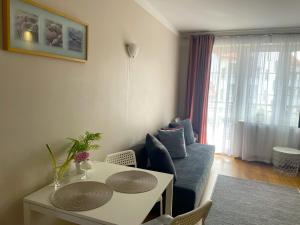 uma sala de estar com um sofá e uma mesa em Apartament Agaciula em Krynica Morska