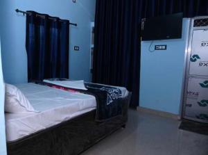 Cama en habitación con cortina negra en OYO Home Om Shanti Palace en Ayodhya