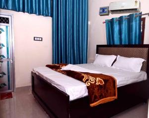 Un dormitorio con una cama con una manta. en OYO Home Om Shanti Palace en Ayodhya