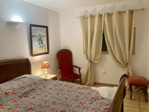 a bedroom with a bed and two chairs and a window at Mas de la pie in Saintes-Maries-de-la-Mer