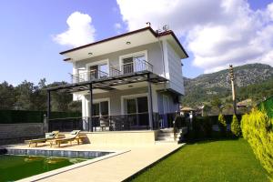 a house with a deck and a swimming pool at golden sand sarıgerme in Dalaman