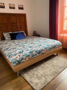 um quarto com uma cama com um edredão azul e laranja em Montreux appartement centre lac em Montreux