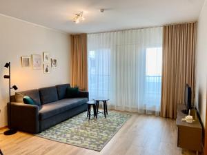 sala de estar con sofá azul y TV en Cozy Foorum Apartment - Tallinn City Centre, en Tallin