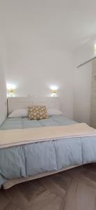 ein großes Bett in einem Schlafzimmer mit einer weißen Wand in der Unterkunft La casa di Cry in Cagliari