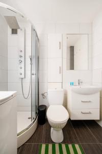 uma casa de banho com um WC, um lavatório e um chuveiro em Atlas Arena Green Studio em Lódź