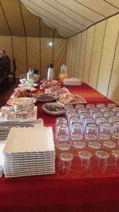 a table in a tent with plates and glasses on it at camp erg znaigui in Taouz