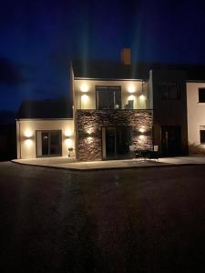 a building with lights on the side of it at night at Emilys Garden 1 in Goleen