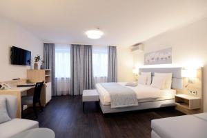 a hotel room with a large bed and a desk at Schlosshotel Ingelfingen in Ingelfingen