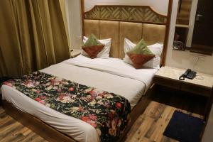 a hotel room with a bed with a floral blanket at HOTEL RV GOLDEN in Amritsar