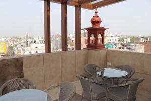 Un balcón con sillas, una mesa y una torre en HOTEL RV GOLDEN en Amritsar