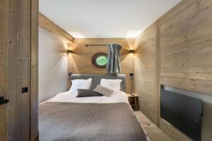 - une chambre avec un lit et un mur en bois dans l'établissement Résidence Phoenix - 4 Pièces pour 8 Personnes 084, à Courchevel