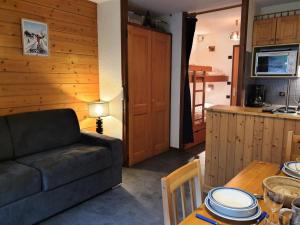 ein Wohnzimmer mit einem Sofa und einem Tisch in der Unterkunft Residence La Corniche - Studio pour 4 Personnes 154 in Morzine
