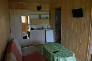 um quarto com uma cozinha, uma mesa e um balcão em Aga domki letniskowe em Rewal