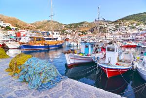 een groep boten is aangemeerd in een haven bij Maison Muse in Hydra