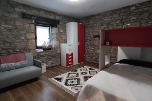 1 dormitorio con cama y pared de piedra en Otsategi, en Múgica