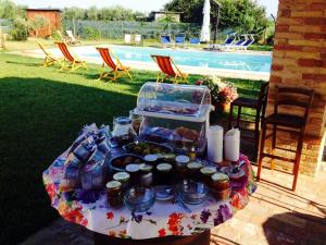 Casale Papa Country Village في لوريتو: طاولة عليها طعام بجوار حمام سباحة
