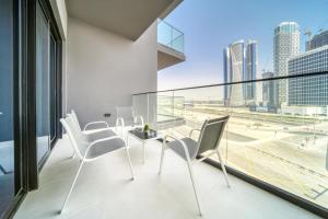 a balcony with white chairs and a view of the city at Burj Khalifa Poolside, Canal Boardwalk, Parking in Dubai