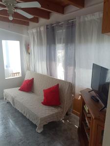 sala de estar con sofá y 2 almohadas rojas en Tranquilo y Acogedor Apartamento, en Orzola