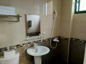 a bathroom with a sink and a toilet and a mirror at Time Traveller - Ganlu Garden in Jinning