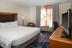 a hotel room with a large bed and a television at Fairfield Inn & Suites Milledgeville in Milledgeville