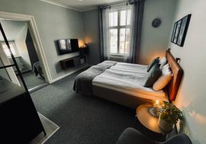 een slaapkamer met een bed en een groot raam bij Telegrafen Lägenhetshotell in Sveg