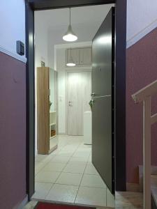 a hallway with a door to a kitchen with a refrigerator at Stefiniki Apartment in Psakoudia