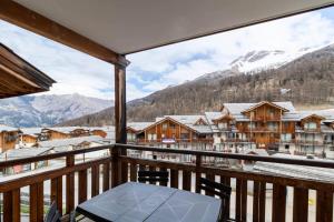 balcone con tavolo, sedie e montagne di Résidence Le Balcon Des Airelles - 2 Pièces pour 4 Personnes 334 a Les Orres