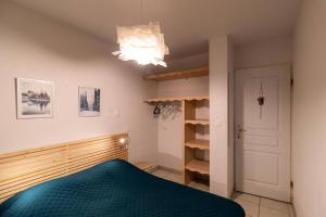 - une chambre avec un lit et un lustre dans l'établissement Résidence Le Balcon Des Airelles - 2 Pièces pour 4 Personnes 504, aux Orres