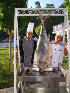 a man and a woman holding a fish on a table at ESTERIA PARK RESORT in Antalya