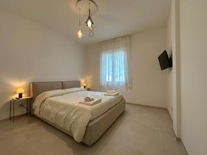 - une chambre blanche avec un grand lit et une fenêtre dans l'établissement Borea Luxury Home, à Otrante