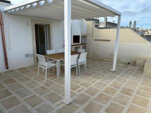 een patio met een tafel en stoelen op een dak bij Borea Luxury Home in Otranto