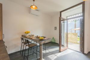 a kitchen with a table and chairs and a large window at Cozy Nest on the lake by Rent All Como in Tremezzo