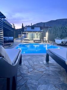 einen Pool in einem Garten mit zwei Bänken und einem Haus in der Unterkunft Two Bedroom Pool House by Olivujoj in Anavyssos