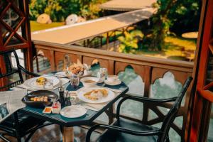 uma mesa com pratos de comida numa varanda em Governor's Residence em Yangon