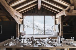 a dining table with a view of a snow covered mountain at Résidence Le Bercail - Chalets pour 12 Personnes 224 in Saint-Martin-de-Belleville