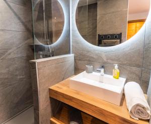 a bathroom with a sink and a mirror at Résidence Domaine Du Loup Blanc - Chalets pour 8 Personnes 514 in Les Orres