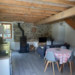 a living room with a table and a wood stove at Les maisons d'Ustou. in Ustou